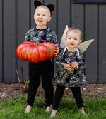 Load image into Gallery viewer, Sibling wearing matching spiderweb print outfits from Burt's Bees Baby holding orange pumpkin
