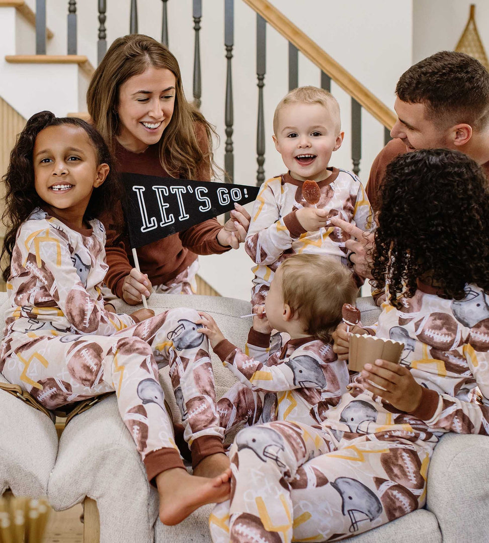 Full family wearing Burt's Bees Baby football holiday matching family pajamas