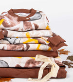 Load image into Gallery viewer, Stacked matching family pajamas with Burt&#39;s Bees Baby football season print
